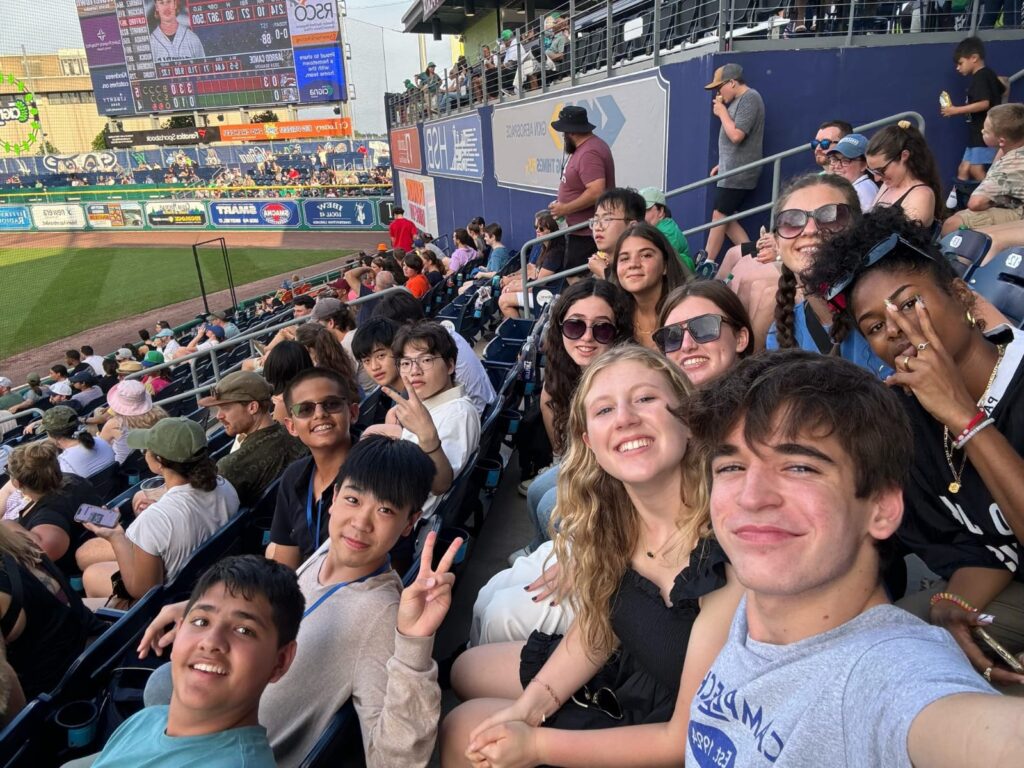 Math seminar group sitting in stands of a baseball game