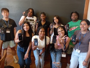 group of students holding phones showing bitcoin