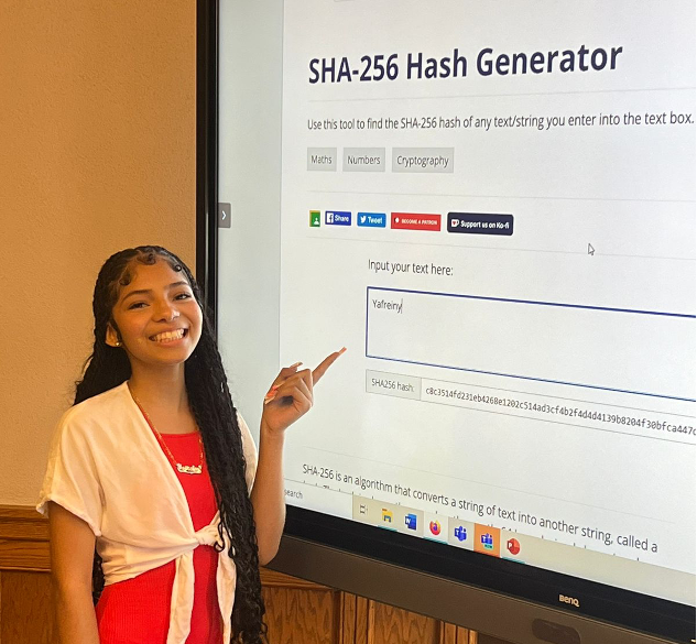 student pointing to projected screen that reads "SHA-256 Hash Generator"