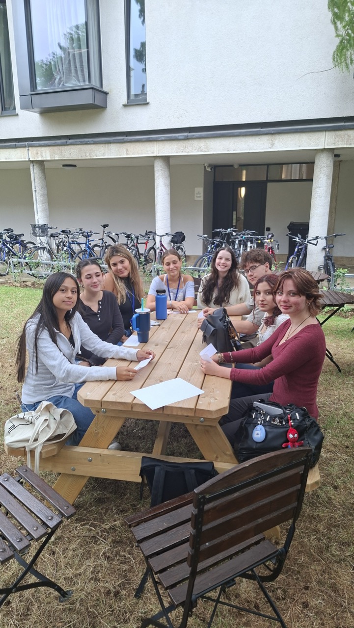 Group of students sit outside at a picnic table