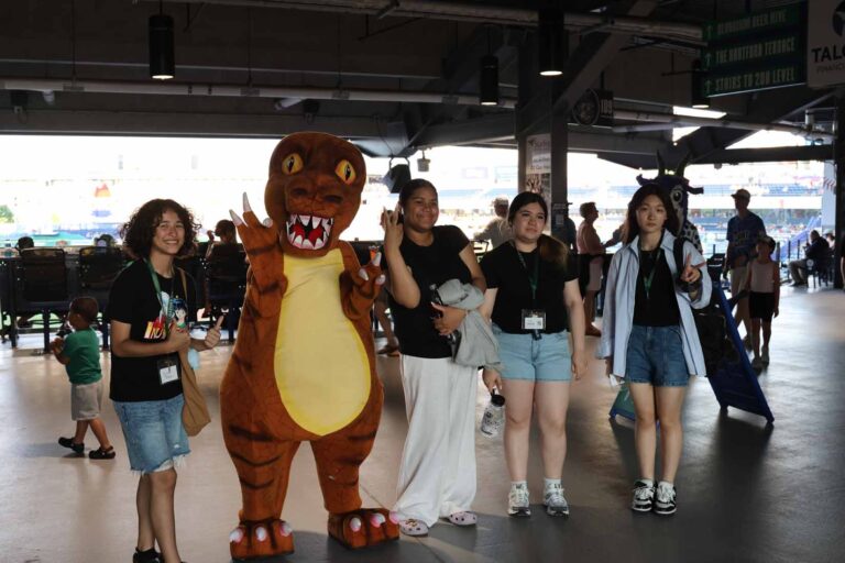 Group of student pose with dinosaur mascot
