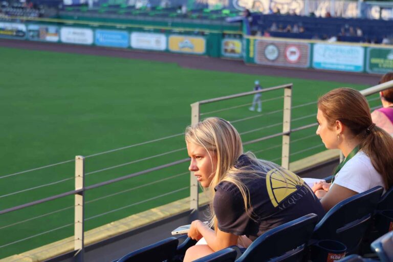 Student looks out at field from seat in stadium