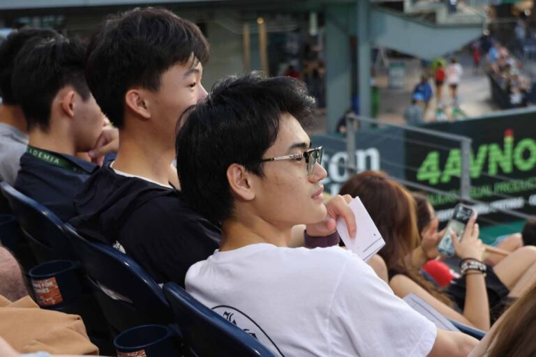 Student sit in stadium looking out at field