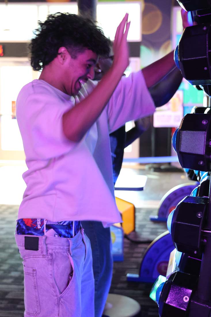 Student pushes buttons on arcade game