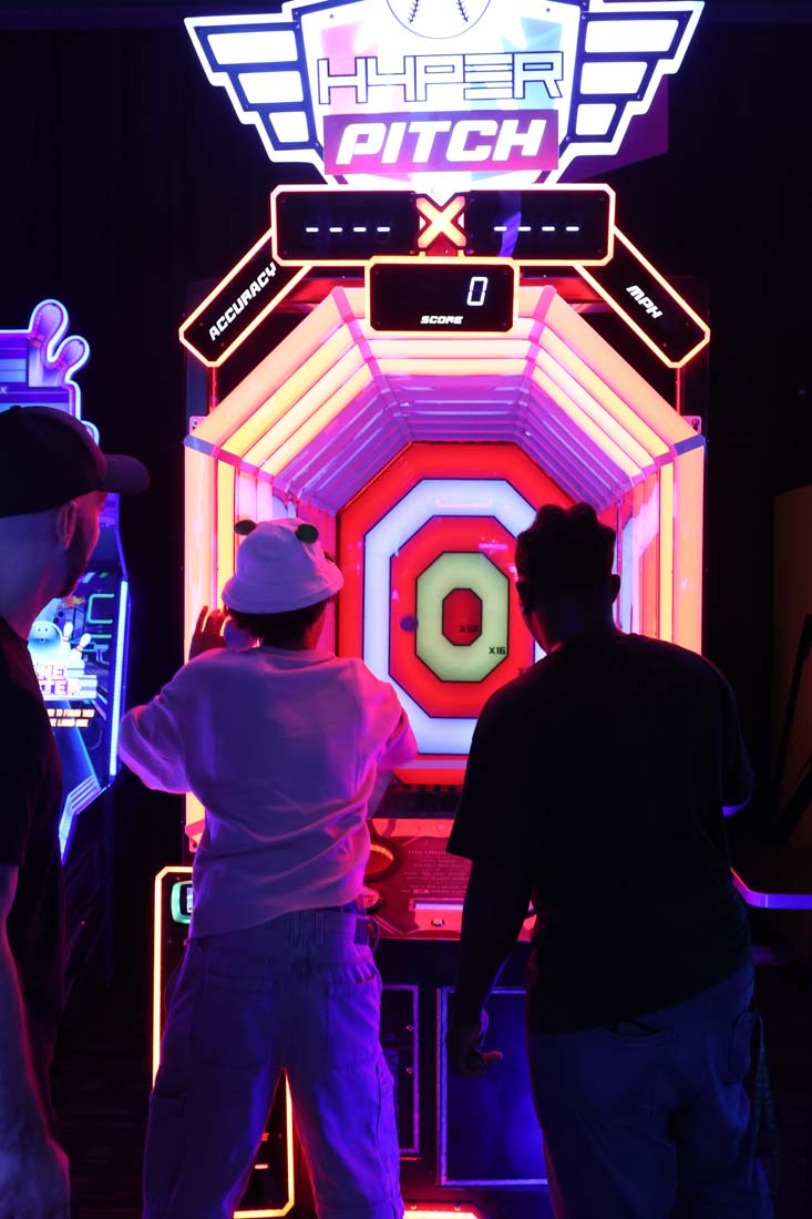 Two students play colorful glowing arcade game