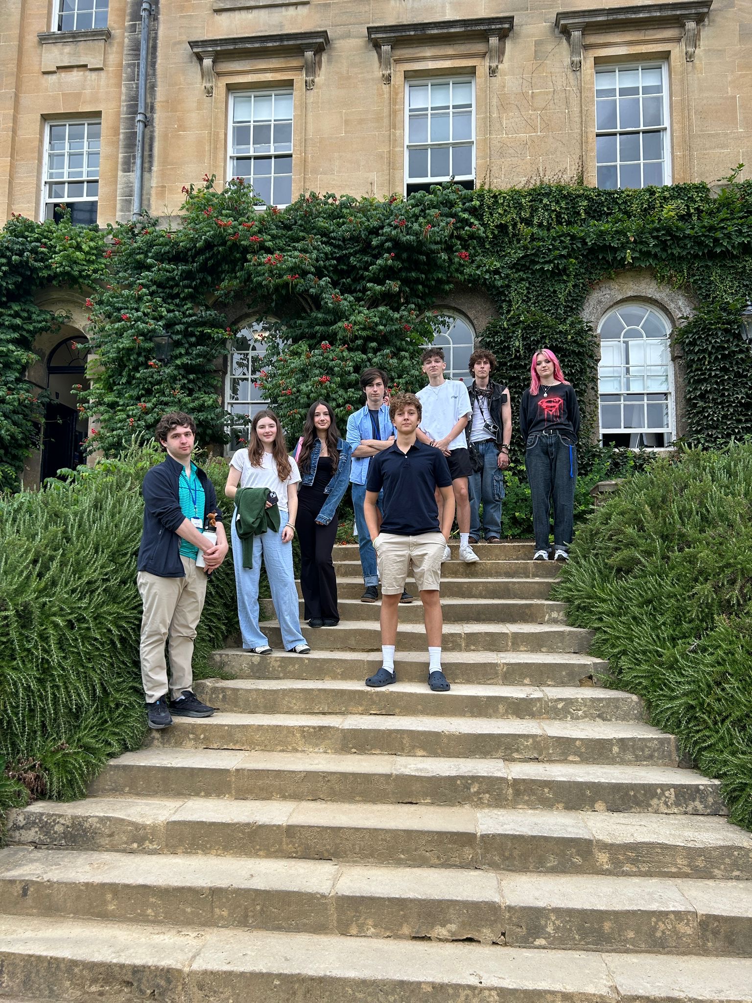 Students pose for a group photo outside on the steps on building on Oxford campus