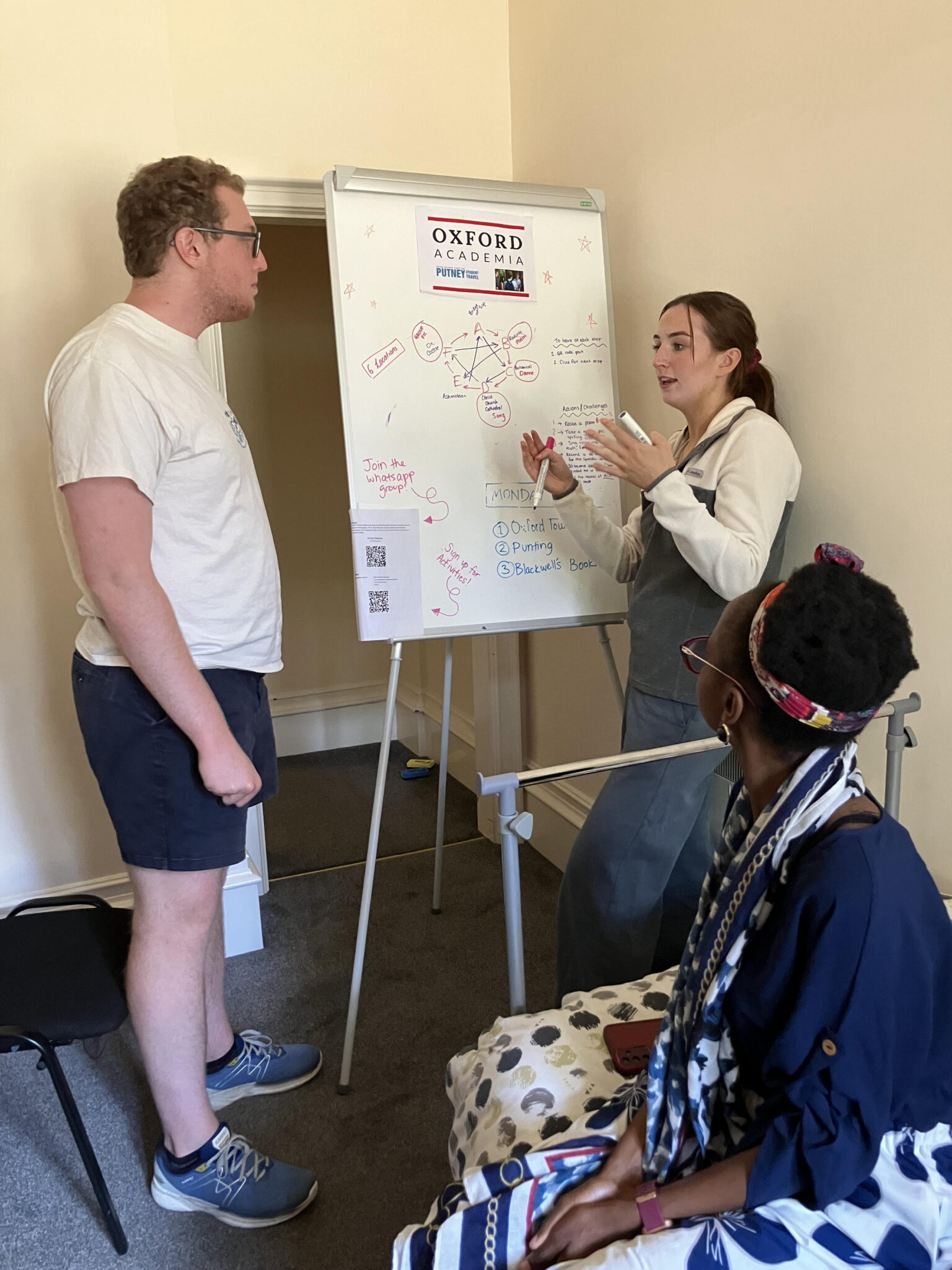 Three staff members gather near a white board planning an activity