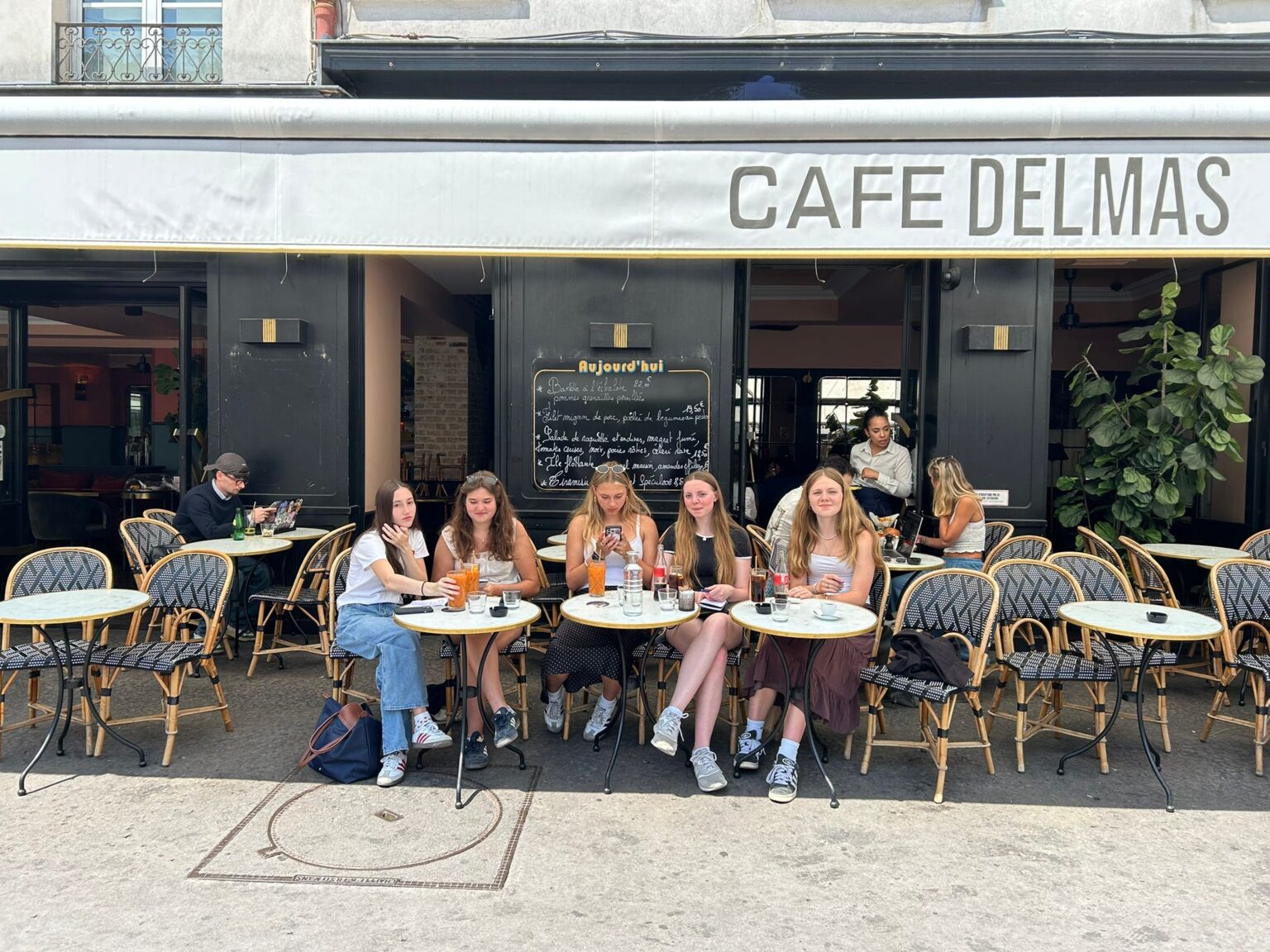 Group of student sit outside a cafe in Paris