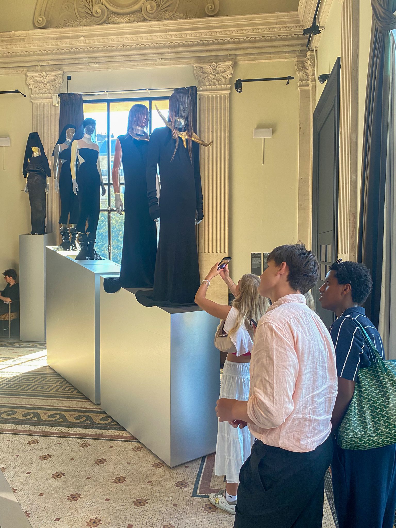 Three students look at fashion display at Palais Galliera