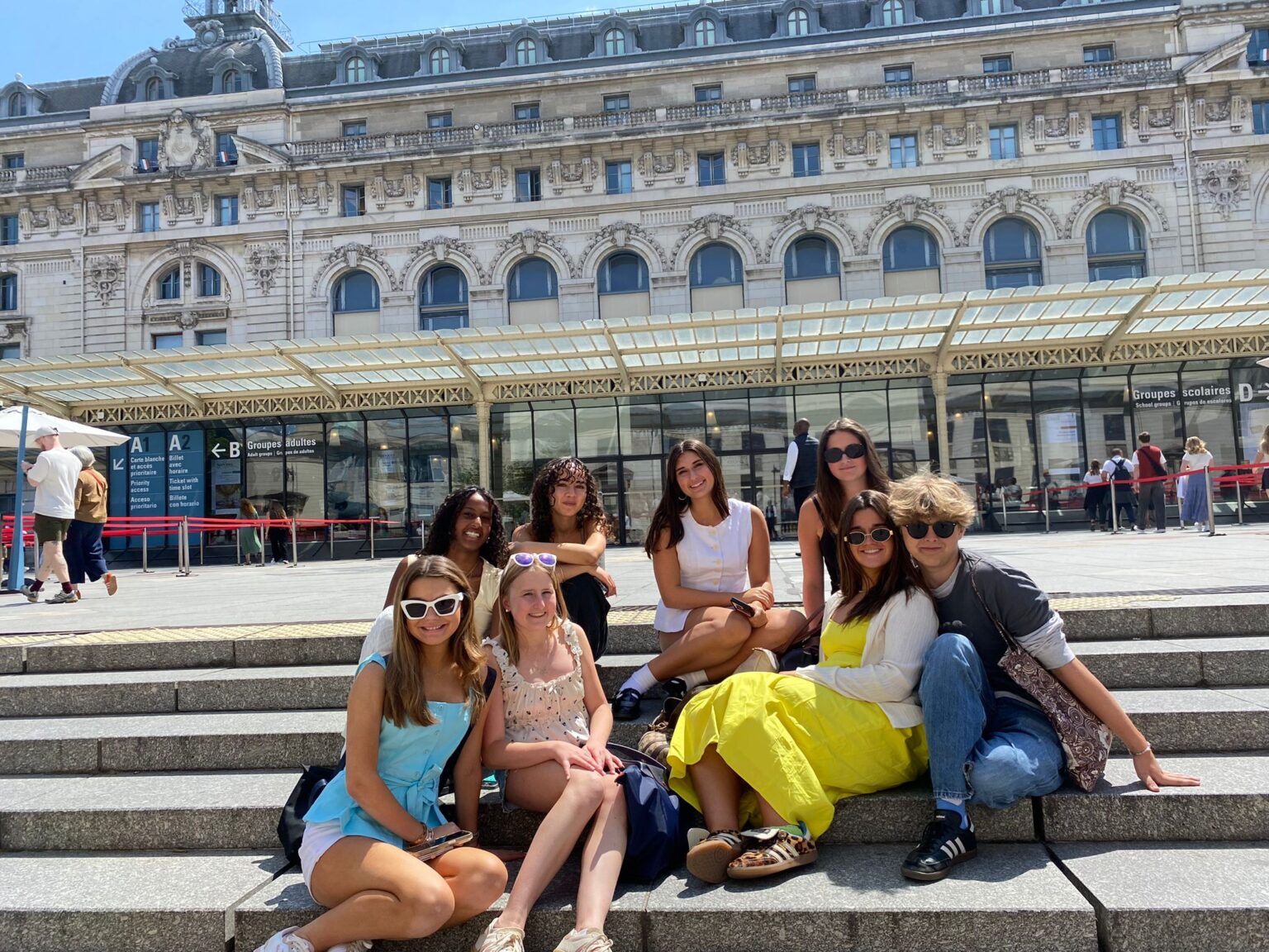 Group of students pose for a group photo on the steps in front of the Musée d’Orsay