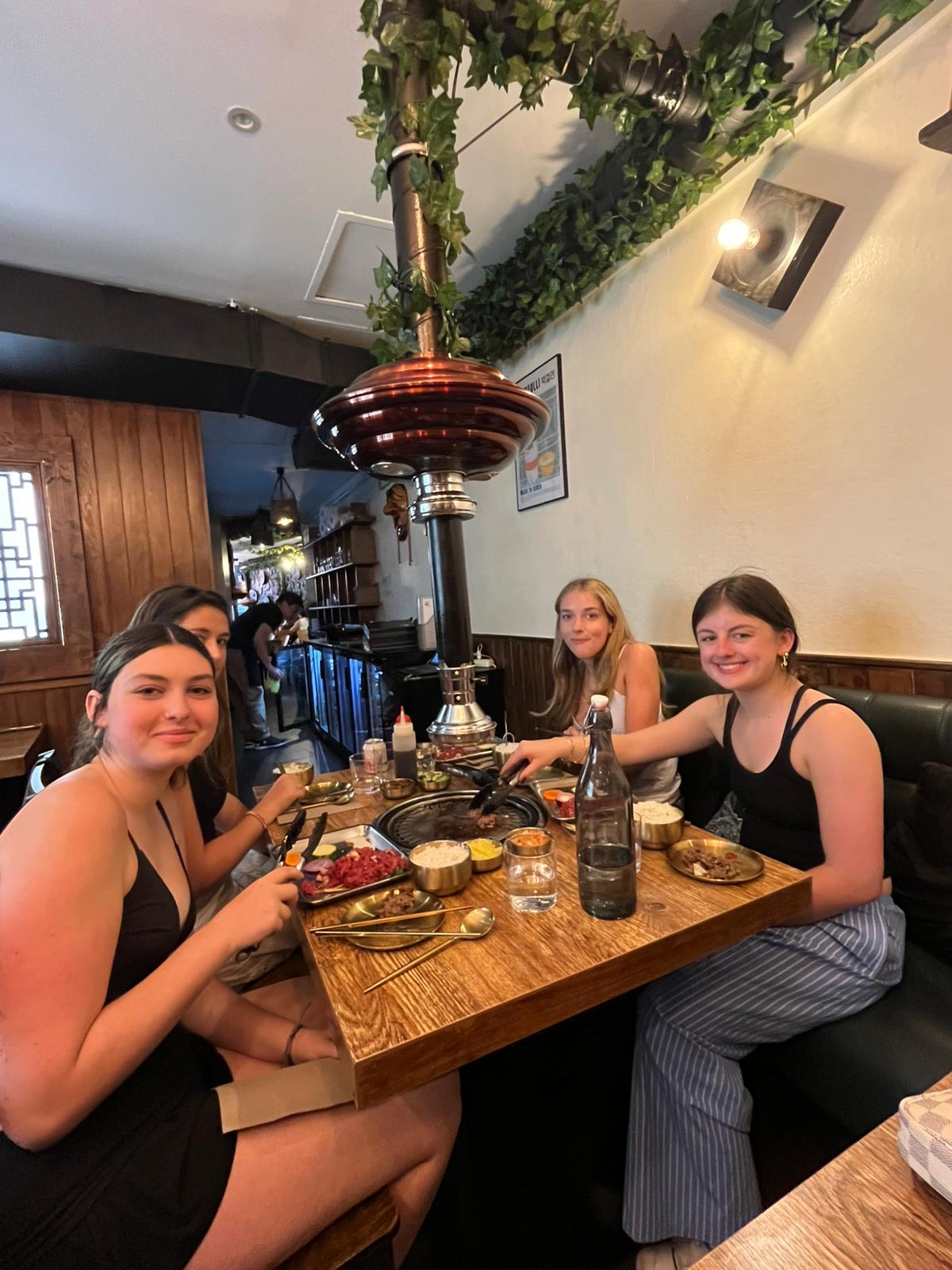 Group of student sit a dinner table smiling for the camera