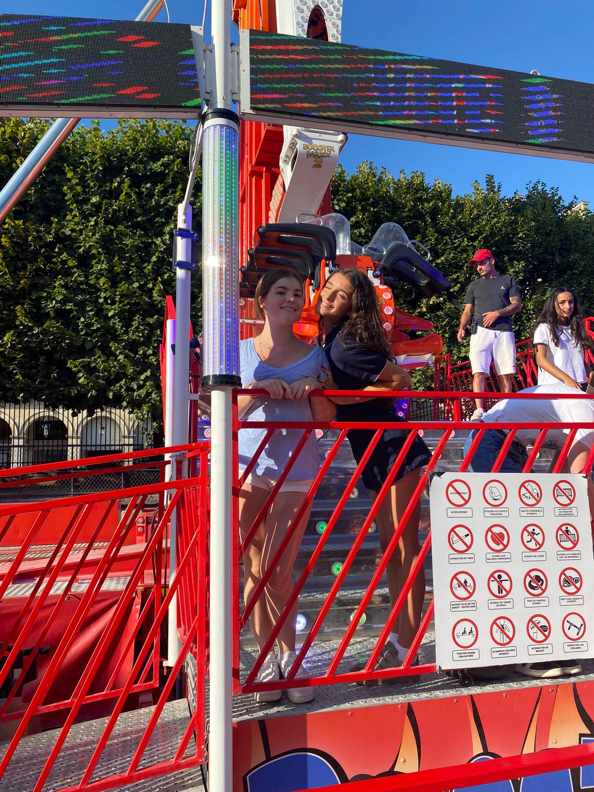 Two student pose for a picture together before boarding a carnival ride