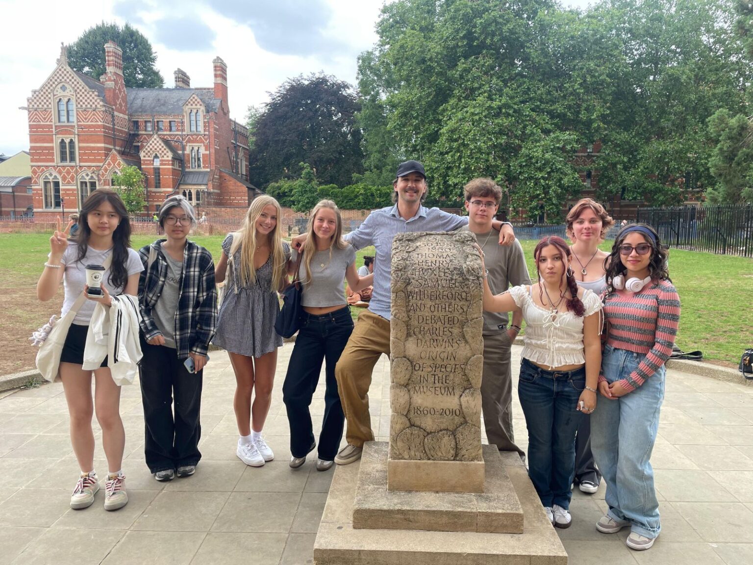 Students and instructor pose for group photo with stone tablet 