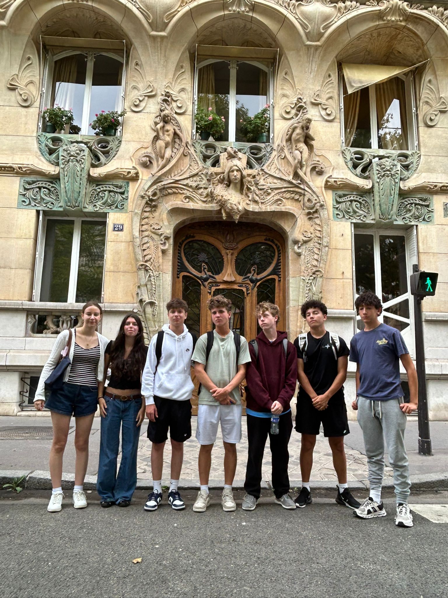 Students stand in front of a decorative building in Paris