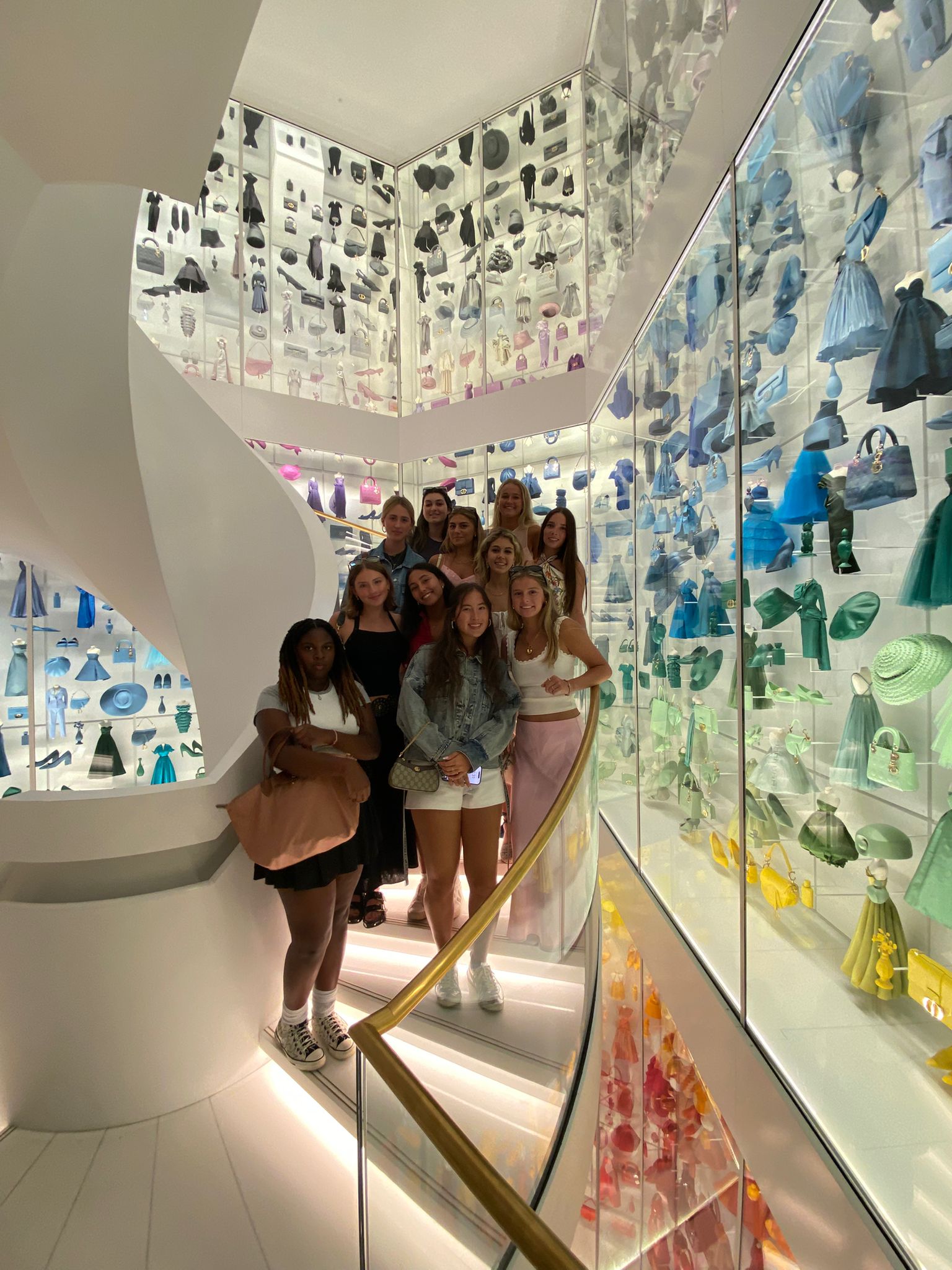Students pose for group photo in colorful staircase