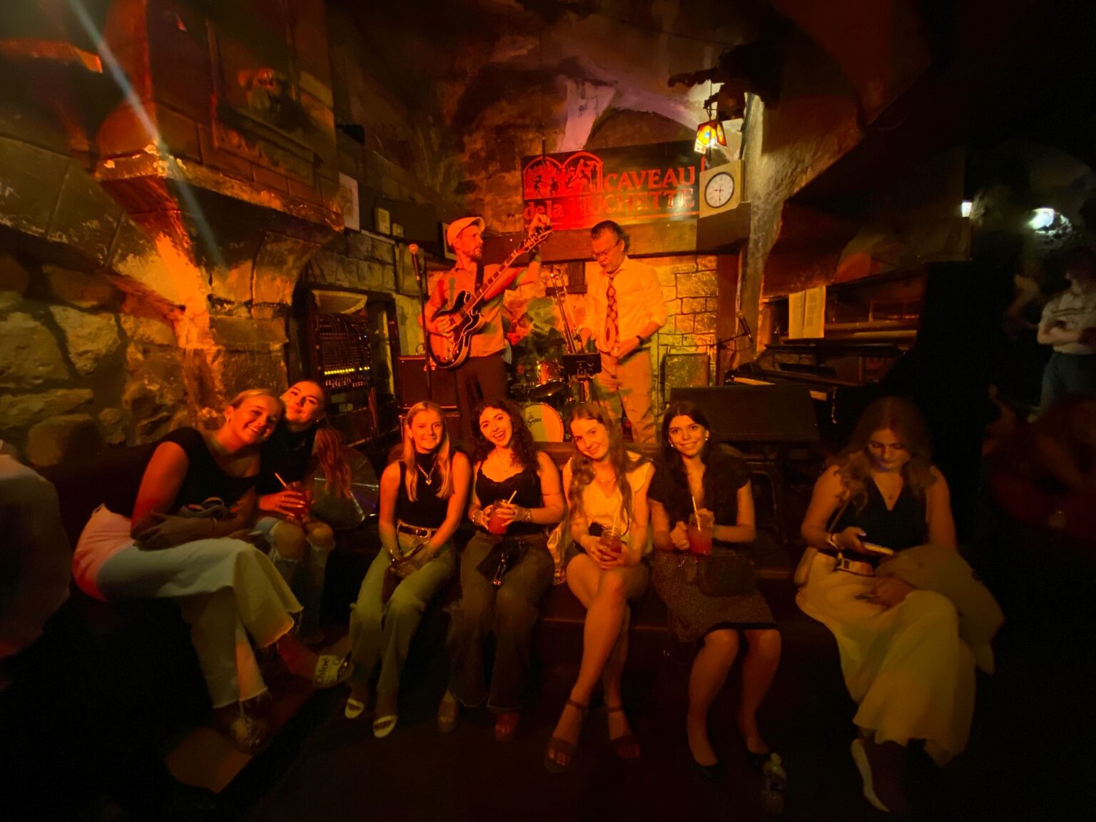 Student pose for picture in front of jazz club performers