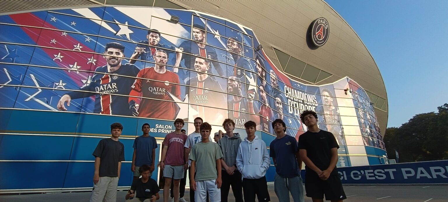 Students pose for group photo outside of Parc des Princes stadium