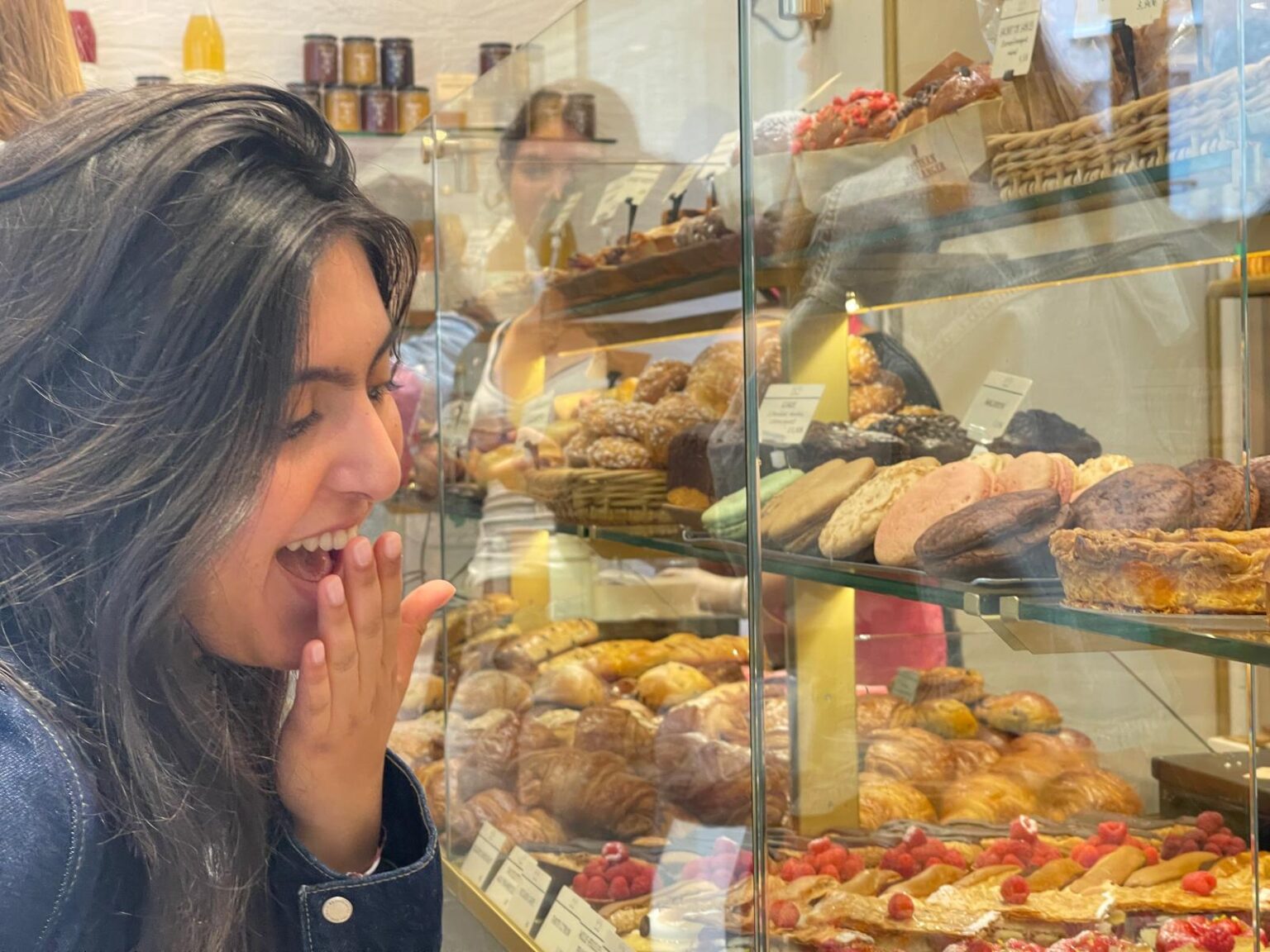 Student looks excitedly at french pastries in display window