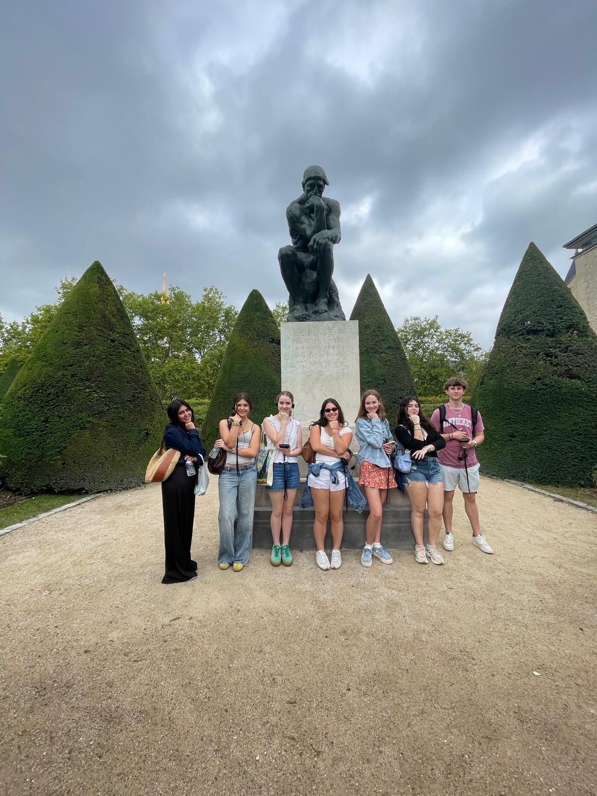 Students pose for group photo in front of Rodin Thinker sculpture 