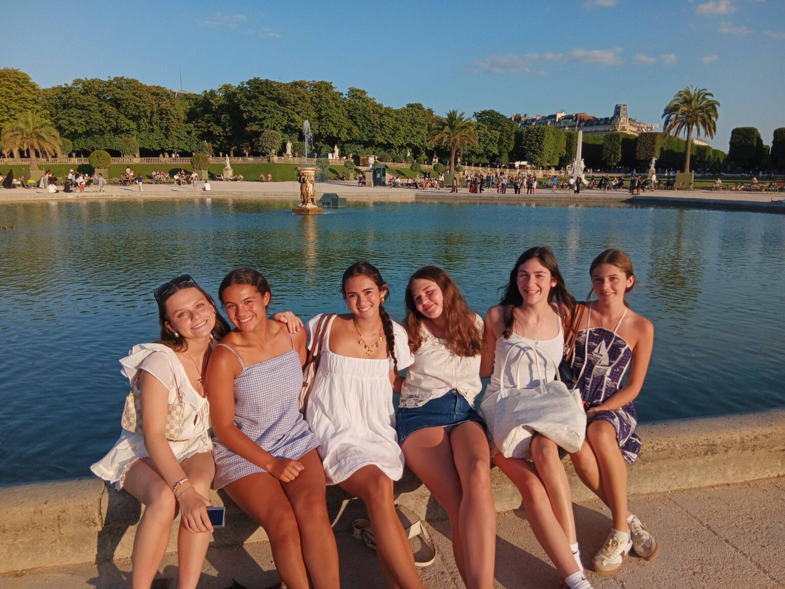 Group of student sit by the water posing for a picture