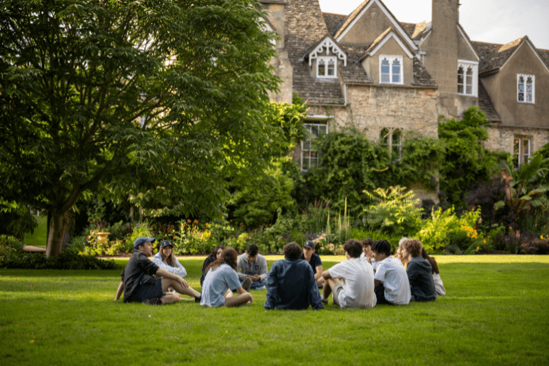 students sitting on lawn in oxford